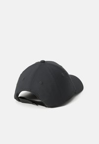 Sort justerbar baseball cap set fra ryggen, der fremhæver stofstroppen og metalspændet på en hvid baggrund.