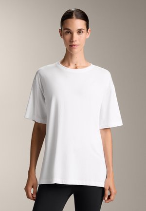 White oversized t-shirt made from soft cotton, featuring a classic crew neck, short sleeves, and a relaxed fit. Minimalistic design, no patterns.