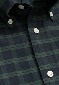 Košilě s button-up zapínáním v tmavě námořnické a zelené kostkované vzoru, s bílými plastovými knoflíky a strukturovaným límcem, texturovaná látka.