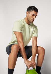 Nike Performance CREW SOLID - Spordi T-särk - olive aura