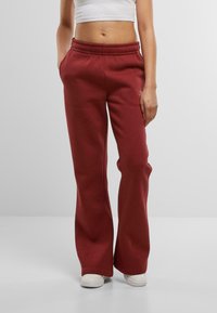 Bordo treniņbikses ar elastīgu jostasvietu, sānu kabatām un brīvu piegriezumu. Izgatavotas no mīkstas auduma ar gludu tekstūru.