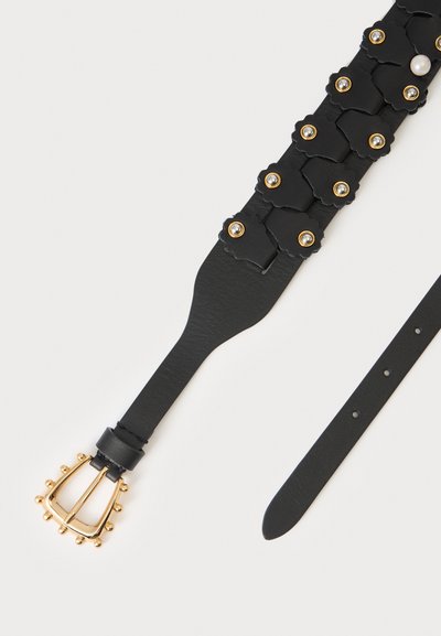Ceinture en cuir noir avec des clous décoratifs dorés, des patchs en cuir en forme de fleur, une perle unique et une boucle dorée avec des ornements ronds.