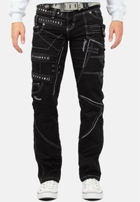 Pantaloni cargo neri con cuciture bianche, caratterizzati da numerose tasche e dettagli con cinghie. Realizzati in tessuto di denim con taglio dritto.