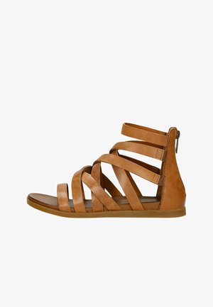 Plochý hnědý kožený gladiátorský sandál s více horizontálními pásky a zadním zipem, zobrazený ze strany.