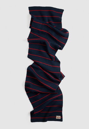 Sciarpa lavorata a maglia blu navy con sottili strisce orizzontali rosse e un piccolo etichetta rettangolare del marchio a un'estremità.