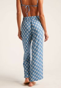 Pantalones azul claro con un patrón floral blanco. Hechos de una tela suave, con un corte relajado y una cinturilla elástica para mayor comodidad.