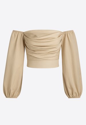 Beżowa bluzka z odkrytymi ramionami i długimi, bufkami rękawami. Z przodu marszczona tkanina i elastyczne mankiety dla dopasowanego wyglądu.