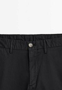 Pantaloni neri con una trama liscia, dotati di chiusura con bottone in metallo, passanti per la cintura e un design della vita pulito.