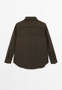 Brun langærmet skjorte lavet af tekstureret stof med spids krave, knapmanchetter og en buet kant, der har et enkelt, ensfarvet design.