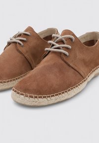 Zapatos de ante marrón con puntera redondeada, diseño de cordones y suela de yute texturizada estilo alpargatas. Livianos y informales.