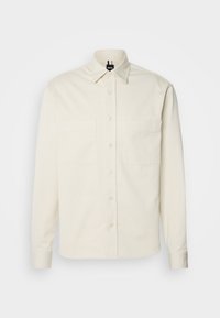 Chemise crème à manches longues avec fermeture à boutons, deux poches poitrine, col pointu et petit logo BOSS sur la poche droite.