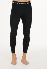 Leggings de compression noirs avec une texture lisse, dotés d'une large taille élastique étiquetée "ENDURANCE". Design ajusté, style long.