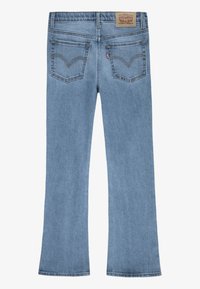Helle blaue Denim-Jeans mit einem ausgestellten Bein-Design, ausgestattet mit zwei Gesäßtaschen mit Stickereidetails und einem Logo-Patch am Bund.