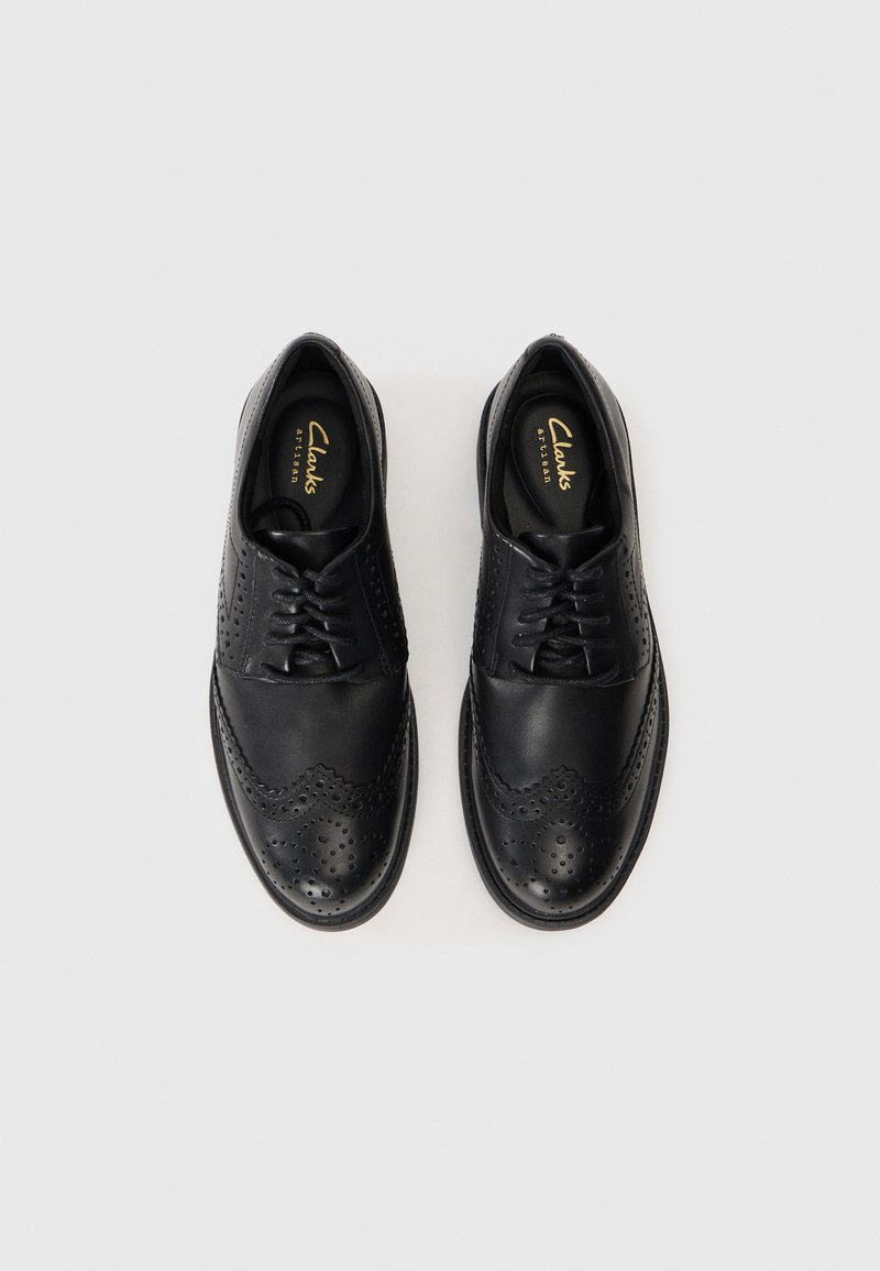 Zapatos brogue de cuero negro con detalles perforados, diseño con cordones y un acabado suave. Cuenta con una suela duradera para ofrecer tracción.