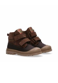 Bruine hoge boots met dubbele klittenbandsluitingen, rubberen teenbescherming en gestructureerde zolen; gemaakt van leer en synthetische materialen.