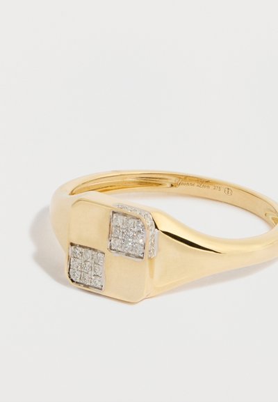 Arany gyűrű, amelynek lapos, négyzet alakú tetején két gyémánttal díszített négyzet található. Sima karika polírozott felülettel. Gravírozott belső rész.