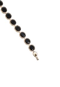 Bracciale in tonalità oro caratterizzato da diversi ovali di pietre nere, ciascuna incassata in una montatura decorativa, con una chiusura sicura a un'estremità.