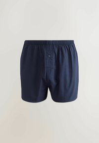 Marinblå bomullskalsonger med elastisk midja, en enda knapp fram och en slät, lätt textur.