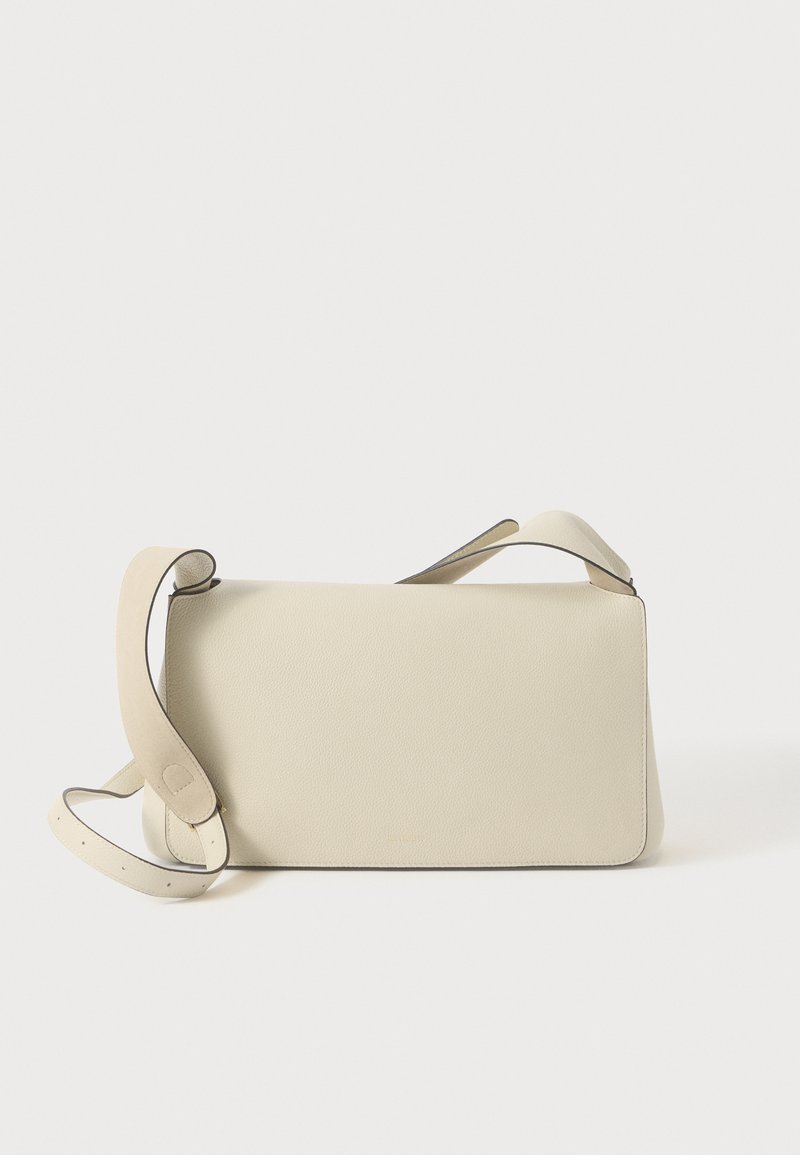 Krémová kožená taška cez rameno s nastaviteľným popruhom a klopou, na čistom bielom pozadí.