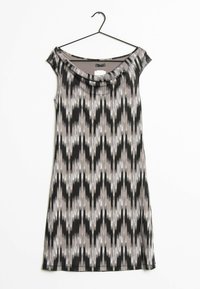 Robe sans manches avec un col drapé dans un motif géométrique noir, blanc et gris. Fabriquée à partir d'un tissu léger et lisse ; suspendue à un crochet noir.