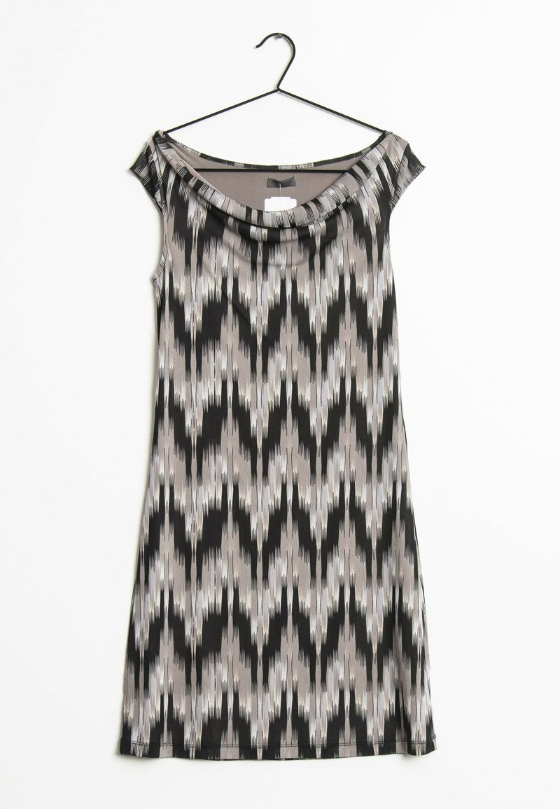 Robe sans manches avec un col drapé dans un motif géométrique noir, blanc et gris. Fabriquée à partir d'un tissu léger et lisse ; suspendue à un crochet noir.