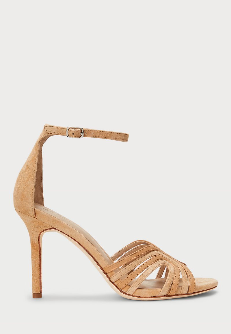 Γυμνές σουέτ σαμπάνιες με ψηλό τακούνι, λεπτές λουρίδες, ρυθμιζόμενη λουρίδα στον αστράγαλο και σχέδιο σε μυτερή μύτη. Διαθέτει κομψό τακούνι στιλέτο.