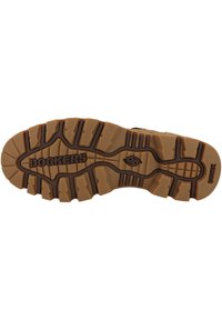 Suela de zapato de goma color bronce con diseño de tracción multidireccional, marca en relieve y una combinación de superficies texturizadas y lisas.
