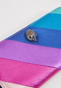 Portafoglio in pelle multicolore con un motivo a strisce diagonali blu, viola e rosa. Presenta un accento decorativo a forma di gufo metallico con gemme colorate.
