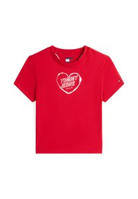 T-shirt rossa in cotone a maniche corte con un disegno di cuore bianco e la scritta "TOMMY JEANS Since 85" in un carattere grassetto. Logo distintivo sulla manica.