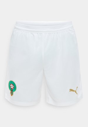 Shorts de sport blancs avec taille élastique, présentant un écusson brodé coloré sur la jambe gauche et un logo Puma doré sur la jambe droite.