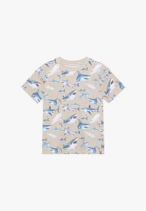 T-shirt beige à manches courtes avec un motif de requin en bleu et blanc. Matière en coton avec un col côtelé. Coupe décontractée.