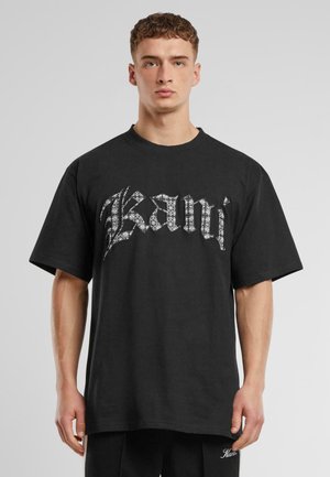 Black cotton t-shirt with a loose fit, featuring a prominent white graphic design of the word "Kanji" across the front.