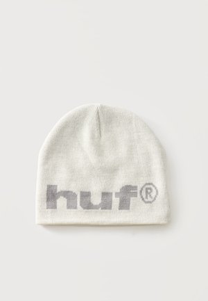Bonnet en tricot blanc avec texte gris "huf" et symbole de marque déposée à l’avant, présenté sur un fond clair uni.