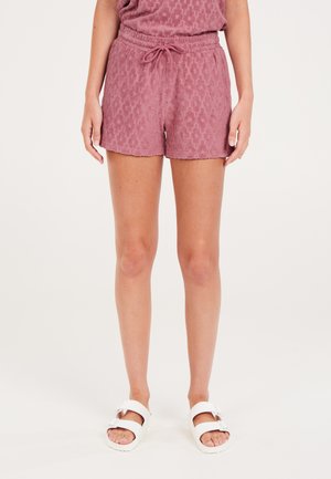 Roze terry-katoenen shorts met een textuurpatroon, elastische tailleband en trekkoord. Vergezeld van witte sandalen met een gesp.