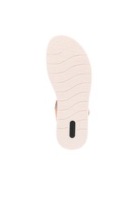 Semelle de sandale avec une semelle en caoutchouc blanc texturé à motif ondulé et une étiquette logo noire. La tige est rose clair avec des accents métalliques.