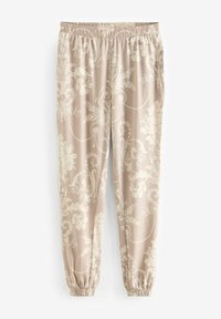 Patronen joggingbroek in zacht beige stof met een wit bloemenpatroon. Voorzien van een elastische tailleband en boorden. Zachte textuur, relaxed fit.