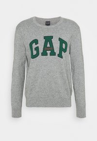 Grijze gebreide trui met lange mouwen met groene GAP-letters en kleine rode "Original" tekst in het midden aan de voorkant.