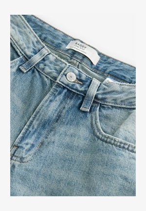 Ralo nizki jeans v svetlo modrem denim materialu s postaranimi predeli, z kovinskim gumbom za zapiranje in vidnimi šivi ob šivih.