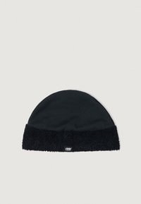 Căciulă neagră din tricot, cu un tiv moale, texturat și pufoș. Corpul principal este neted, cu un finisaj ușor lucios. Dispune de un mic etichetă cu logo pe tiv.