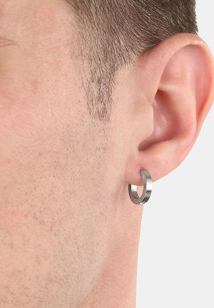 Orecchino ad anello in metallo con una finitura argento lucido. Il design presenta una superficie liscia e una forma circolare, adattandosi perfettamente al lobo dell'orecchio.