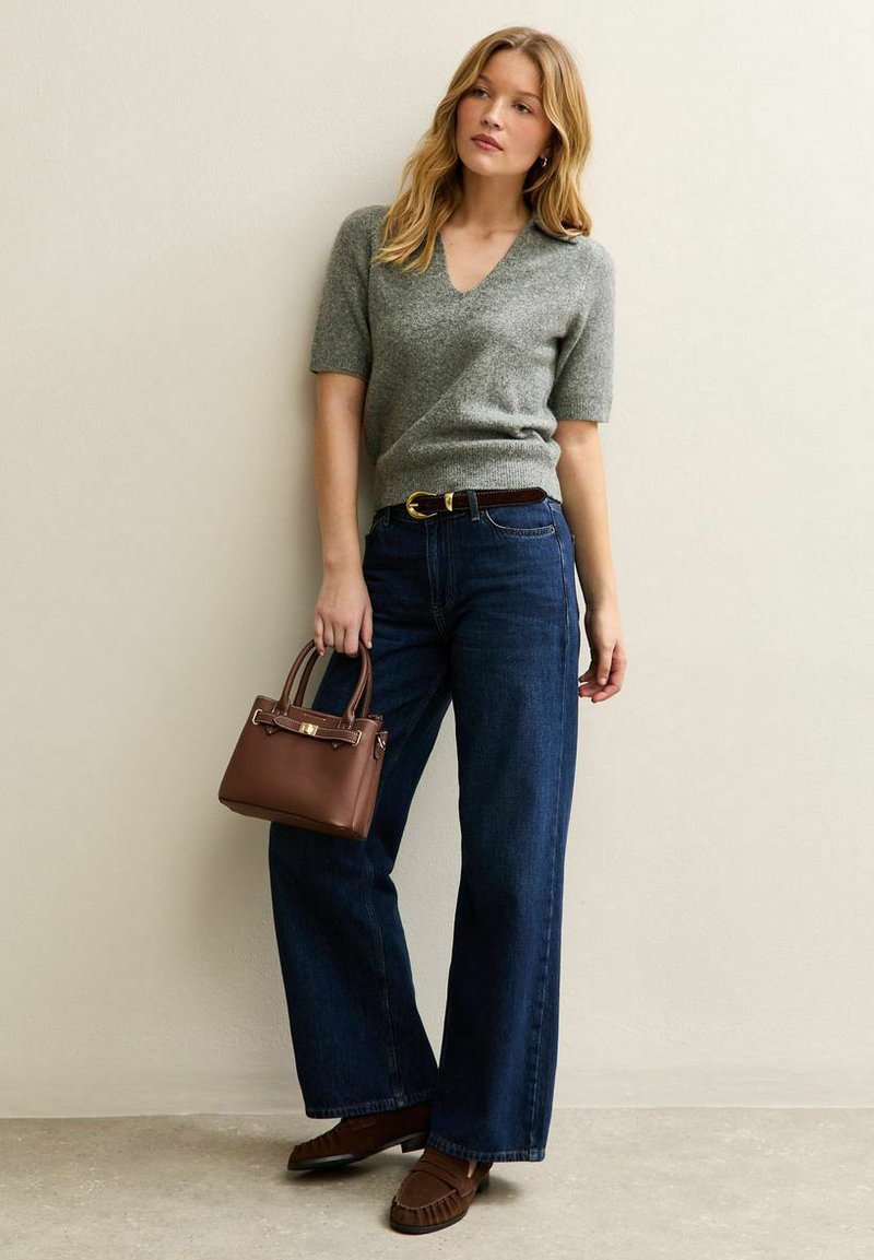 Grijs truitje met korte mouwen, donkerblauwe wijde spijkerbroek, bruine handtas met gouden accenten en bruine loafers. Soepele textuur, casual pasvorm.