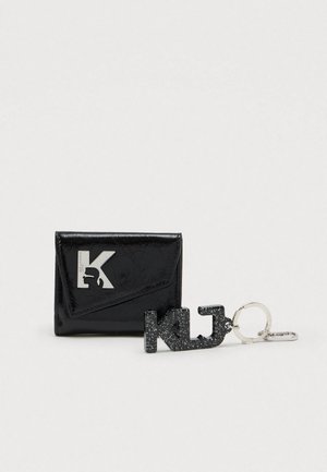 Portefeuille noir brillant avec logo "K" argenté et porte-clés K|J noir moucheté avec anneau et fermoir argentés sur fond blanc.