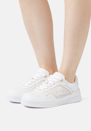 Sneakers bianchi con rete testurizzata e accentuazioni in pelle liscia. Presentano un design con lacci, colletto imbottito e dettaglio del logo sul lato.
