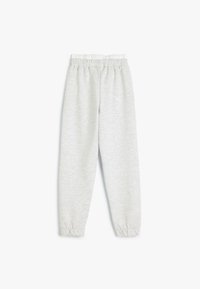 Pantalones de chándal gris claro con cintura elástica, puños ajustados y una textura suave, de color sólido y sin patrones ni adornos visibles.