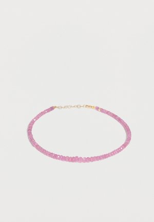 Delicaat armbandje met kleine, facetgeslepen roze kralen en een gouden sluiting op een effen witte achtergrond.