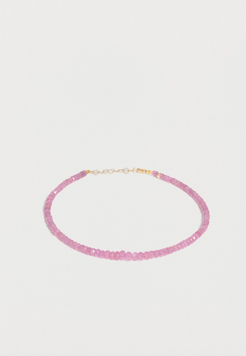 Λεπτό βραχιόλι με μικρές, γυαλιστερές ροζ χάντρες και χρυσό κούμπωμα σε απλό λευκό φόντο.