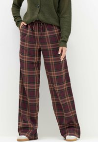 Burgundy, green ja brown värvides ruudulised laiad püksid, mis on varustatud elastse vöökoha ja nööriga, pakkudes mugavat lõiget.