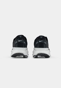 Pantofi sport negri și gri cu un superior din plasă texturată, talpă albă amortizată și talpă exterioară din cauciuc negru, având un logo subtil.