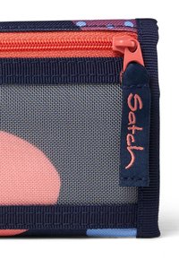 Rechthoekige stoffen pouch met een marineblauwe achtergrond, koraalkleurige rits en een roze cirkelpatroon. Inclusief het "Satch" logo aan de zijkant.