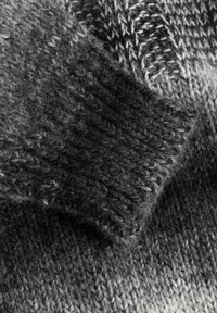 Strickpullover in Farbverlauf von Grau. Mit gerippten Bündchen und unterschiedlichen Texturen, die eine weiche, flauschige Oberfläche bieten.